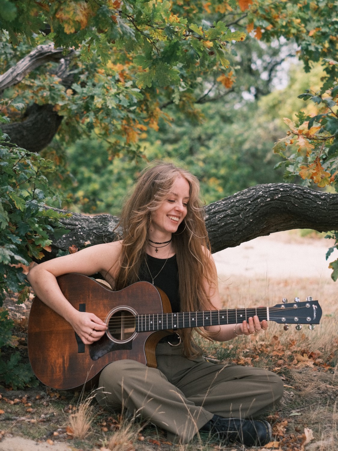  Zangeres Rachelle Adriënne speelt zittend gitaar in Breda